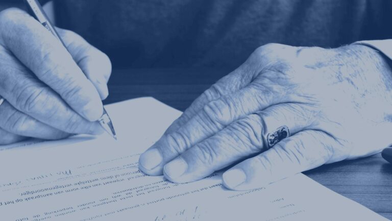 Manos de una persona mayor firmando un documento – abogados de herencias en Barcelona